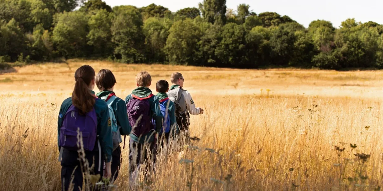 A group of people standing in the grass.